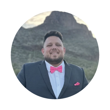 Profile picture of Cody wearing a suit and bowtie with the background of the Tucson, Arizona mountains as the background. 